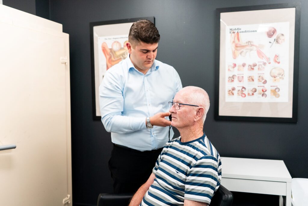 Audiologist checking an older patient before a cochlear implant assessment
